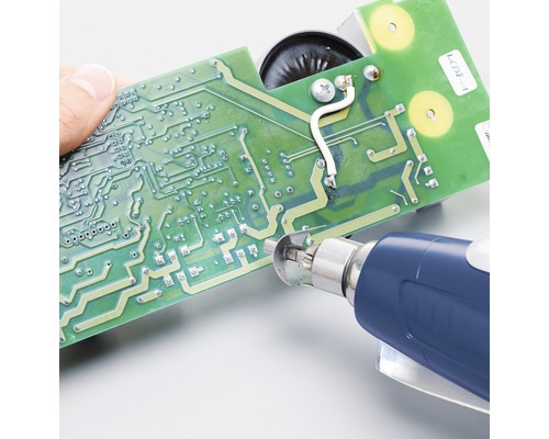 Persoon repareert een printplaat met een soldeerbout.