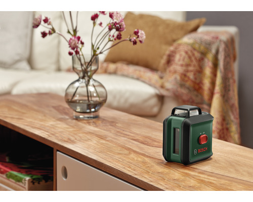 Bosch Logo. Kruislijnlaser op een tafel in de woonkamer.