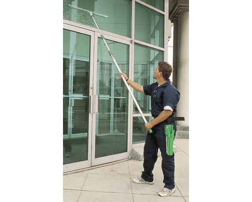 Man reinigt ramen met raamwisser en telescopische steel