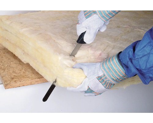 Persoon snijdt minerale wol met een mes.