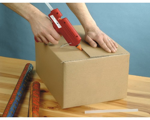 Iemand gebruikt een lijmpistool om een kartonnen doos te sluiten.
