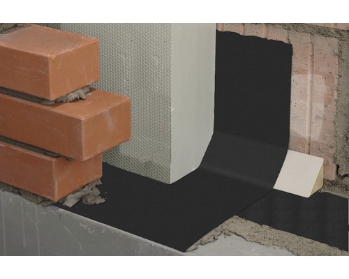 Detailopname van een horizontale barrière van bitumen tussen metselwerk en beton