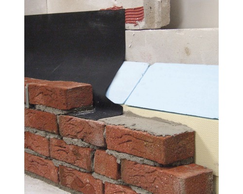 Detailopname van een gemetselde muur met afdichting en isolatie