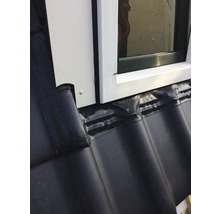 Detailopname van een dakraam met afdichting op een dak met dakpannen