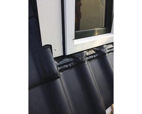 Detailopname van een dakraam met afdichting op een dak met dakpannen