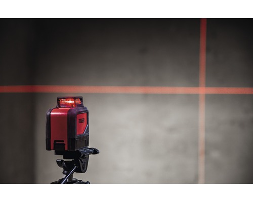 Kruislijnlaser op statief met laserlijnen op de muur
