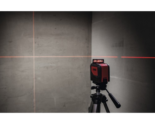 Rode kruislijnlaser op statief projecteert lijnen op een muur