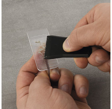 Een persoon gebruikt een reinigingswerktuig om een transparant object te reinigen.
