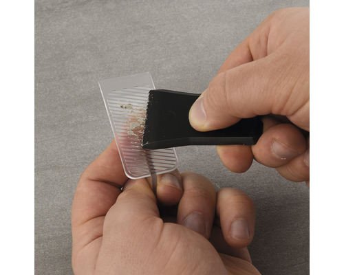 Een persoon gebruikt een reinigingswerktuig om een transparant object te reinigen.