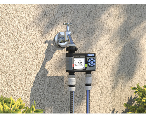 Waterklok op de kraan met twee aangesloten waterslangen