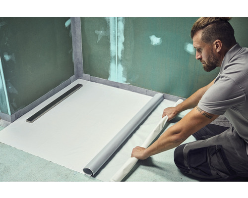 Man legt afdichtingsbaan in de badkamer