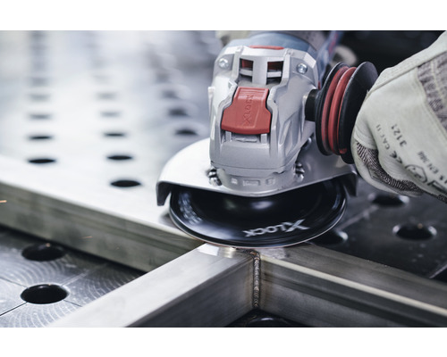 Een persoon gebruikt een haakse slijper om een stuk metaal te slijpen.