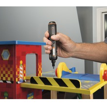 Iemand gebruikt een accuschroevendraaier op een stuk speelgoed.