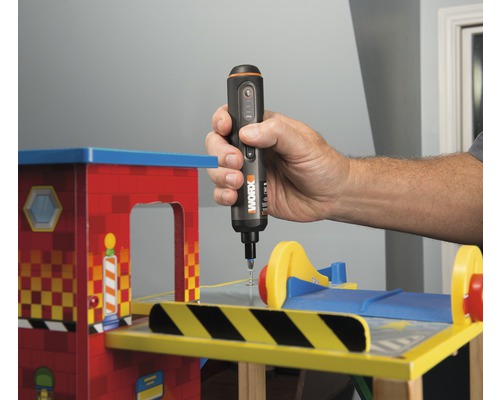 Iemand gebruikt een accuschroevendraaier op een stuk speelgoed.