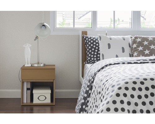 Slaapkamer scène met bed, nachtkastje en lamp.