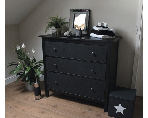 Slaapkamer met zwart dressoir met drie laden, spiegel en kamerplanten