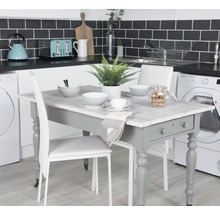 Keukenscène met eettafel, stoelen en huishoudelijke apparaten.