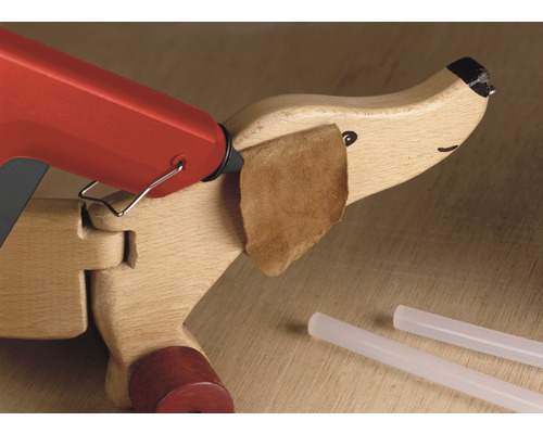 Lijmpistool bij het lijmen van een houten speelgoed met leer