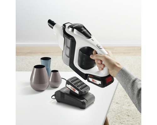 Accu stofzuiger met oplader en diverse vazen op een tafel