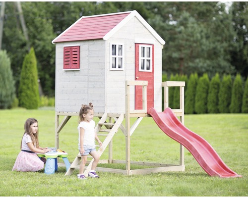 Speelhuis met glijbaan en twee spelende kinderen in de tuin