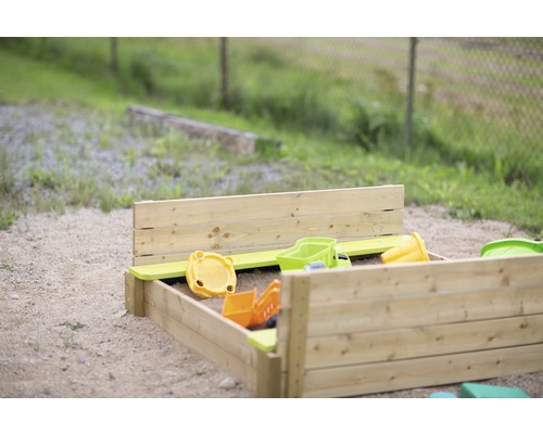 Houten zandbak met speelgoed in de tuin