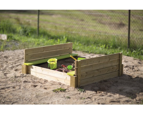 Houten zandbak met speelgoed in de tuin