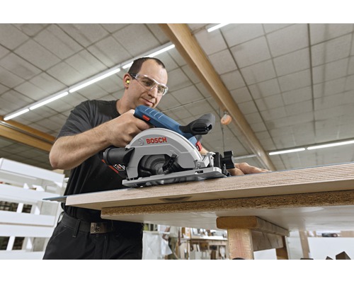 Een man gebruikt een Bosch handcirkelzaag om hout te zagen.