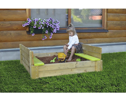 Kind speelt met speelgoed in de zandbak in de tuin