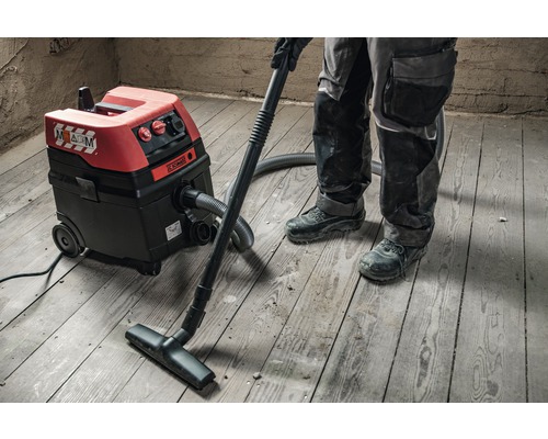 Industriële stofzuiger in gebruik op houten vloer.