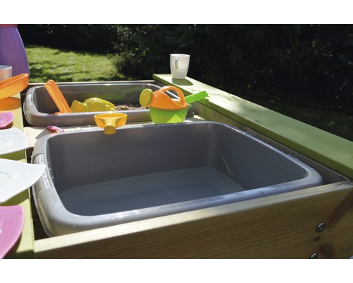 Zand- en watertafel met speelgoed in de tuin