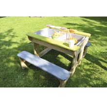 Zand- en watertafel met banken en speelgoed in de tuin