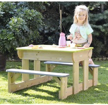 Kind zit aan een picknicktafel met banken in de tuin.