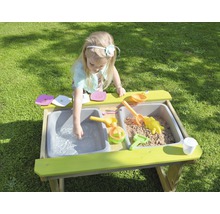 Meisje speelt met zand en water in een modderkeuken in de tuin