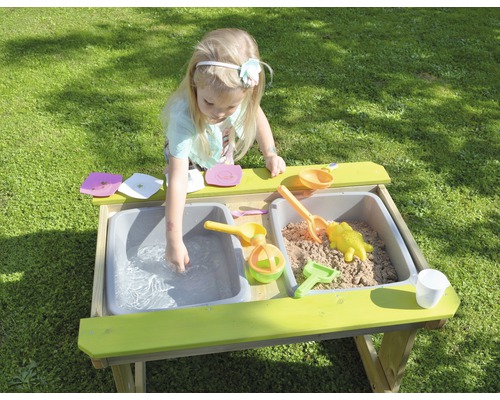 Meisje speelt met zand en water in een modderkeuken in de tuin