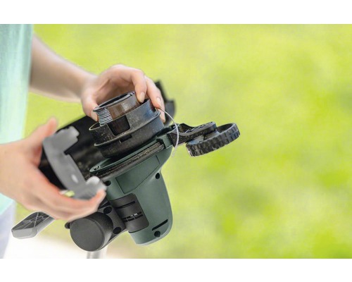 Handen verwisselen spoel van een grastrimmer