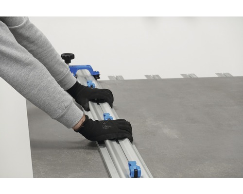 Persoon gebruikt tegelsnijder om tegels te snijden