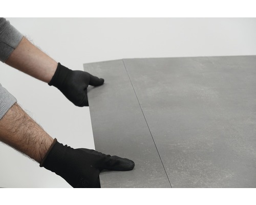 Persoon met handschoenen legt vloerbedekking