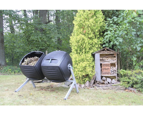 Twee composteer trommels van plastic en een insectenhotel in de tuin