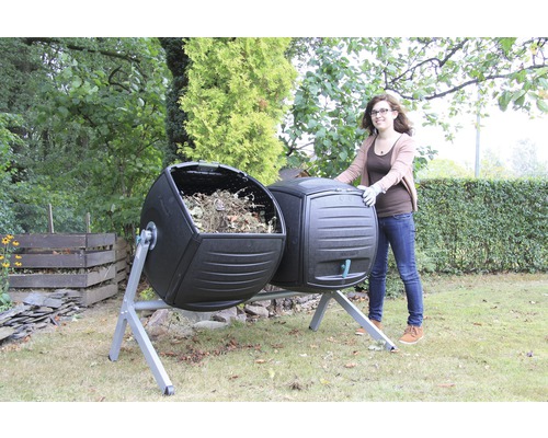 Dubbele composttrommel met vrouw in de tuin