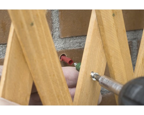 Bevestiging van een houten ladder met schroeven aan een muur