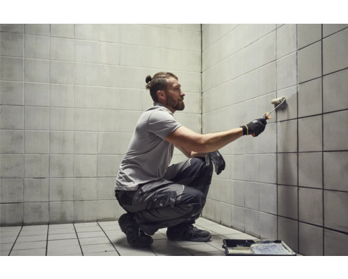 Man schildert tegelwand met verfroller