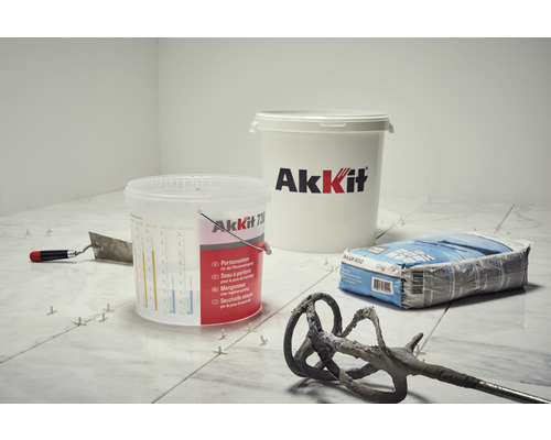 Tegelzetscène met gereedschap, lijm en AkKit-emmer