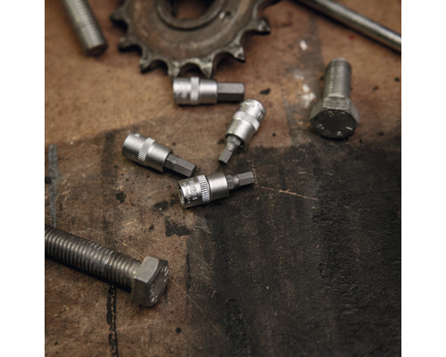 Meerdere moersleutelbits en schroeven op een werkbank.