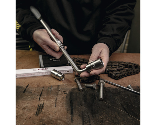 Man hanteert een dopsleutelset op een werkbank