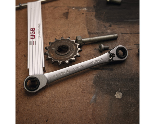 Ratelringsleutel, tandwiel, schroeven en duimstok op een werkbank