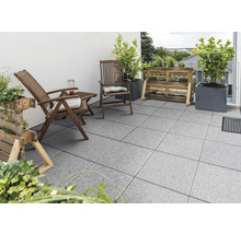 Terras met betonnen terrastegels, houten stoelen en plantenbakken
