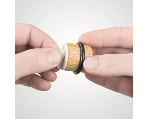 Houten wijnstop met rubberen afdichting wordt vastgehouden door handen