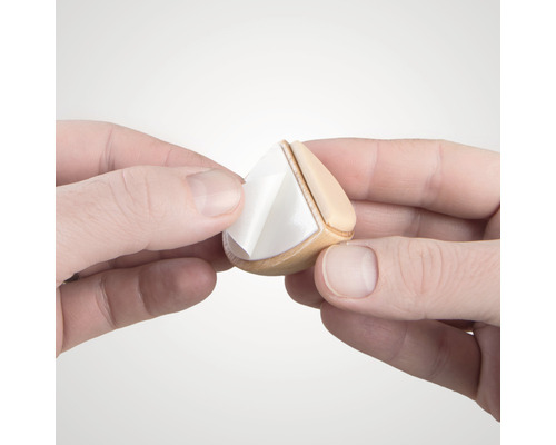 Handen verwijderen beschermfolie van een meubelglijder