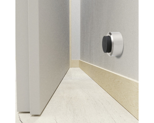 Wanddeurstopper van metaal met rubberen buffer naast een deur