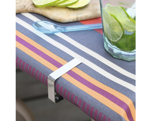 Tafel met tafelkleed, schijfjes limoen, drankje en een metalen tafelkleedhouder